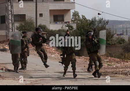 Naplouse. 12 octobre, 2018. Des soldats israéliens fire grenades lacrymogènes à des manifestants palestiniens lors de heurts après une manifestation contre l'expansion des colonies juives de Kufr Qadoom village près de la ville cisjordanienne de Naplouse le 12 octobre, 2018. Credit : Nidal Eshtayeh/Xinhua/Alamy Live News Banque D'Images