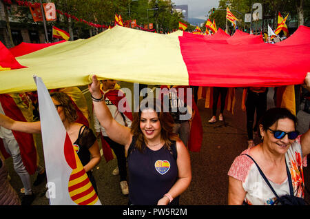Barcelone, Catalogne, Espagne. 12 octobre, 2018. Plusieurs manifestants pour l'unité de l'Espagne sont vus élever un grand drapeau espagnol.Sous la devise de Barcelone, garant de l'Hispanidad, des milliers de manifestants ont démontré pour l'union de l'Espagne et de célébrer le Jour de Christophe Colomb. Credit : Paco Freire SOPA/Images/ZUMA/Alamy Fil Live News Banque D'Images