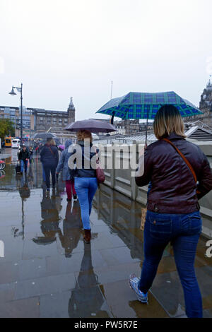 Edinburgh, Ecosse, Royaume-Uni. 12 octobre, 2018. Les gens s'abritant sous des parasols sur le centre-ville d'Édimbourg rues alors que les précipitations a frappé la côte est. Credit : PictureScotland/Alamy Live News Banque D'Images