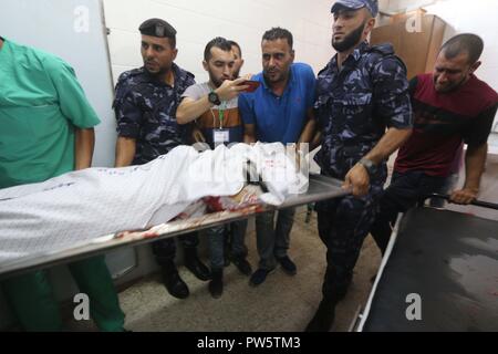 Le centre de la bande de Gaza, la bande de Gaza, en Palestine. 12 octobre, 2018. Bodiy palestiniens sont arrivés à l'hôpital al-Aqsa à Deir el Balah à Gaza a déclaré au ministère de la santé, les forces israéliennes ont tué six Palestiniens, quatre d'entre eux dans un seul incident, dans l'un des plus jours en mois de protestations de masse le long de la barrière de sécurité séparant la bande de Gaza et Israël. Credit : Hassan Jedi et Quds Net News Wire/ZUMA/Alamy Live News Banque D'Images