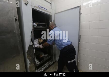 Le centre de la bande de Gaza, la bande de Gaza, en Palestine. 12 octobre, 2018. Bodiy palestiniens sont arrivés à l'hôpital al-Aqsa à Deir el Balah à Gaza a déclaré au ministère de la santé, les forces israéliennes ont tué six Palestiniens, quatre d'entre eux dans un seul incident, dans l'un des plus jours en mois de protestations de masse le long de la barrière de sécurité séparant la bande de Gaza et Israël. Credit : Hassan Jedi et Quds Net News Wire/ZUMA/Alamy Live News Banque D'Images