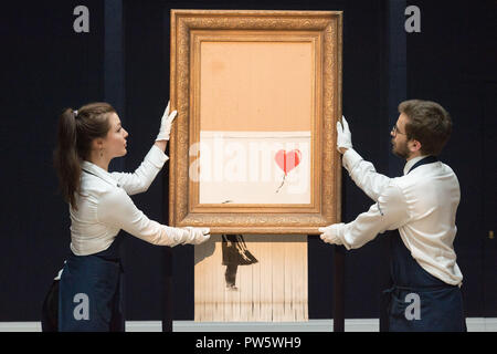 Londres, Royaume-Uni. 12 octobre, 2018. Sotheby's présente les membres du personnel de Banksy, "l'amour est dans le Bin' à Londres, Angleterre le 12 octobre 2018. Initialement intitulé "Girl with Balloon', l'artiste de rue britannique Banksy fait sa peinture s'auto-détruire le 5 instants après qu'il a été vendu aux enchères pour 1,042 millions de livres sterling (1,37 millions de dollars américains) chez Sotheby's à Londres. Crédit : Ray Tang/Xinhua/Alamy Live News Banque D'Images