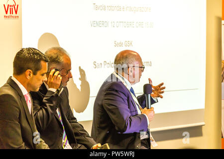 San Polo di Parma, Italie. 12 octobre, 2018. Le professeur Massimo Galli, président de SIMIT Société Italienne de maladies infectieuses et tropicales, parle à l'inauguration de la nouvelle usine de GSK pour produire des médicaments innovateurs pour Fostemsavir, résistantes au traitement des patients atteints du VIH. À sa droite, Tim Tordoff, premier vice-président et chef de l'Europe et plus loin ViiV Luis Arosemena, président et chef de l'Italie. GoneWithTheWind/Alamy Live News Banque D'Images