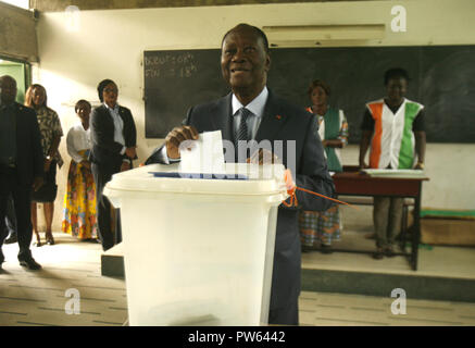 (181013) -- ABIDJAN, 13 octobre 2018 (Xinhua) -- Le président ivoirien Alassane Ouattara jette son bulletin de vote pour l'élections municipales et régionales à un bureau de scrutin à Abidjan, Côte d'Ivoire, le 13 octobre 2018. Les opérations de vote pour les élections locales en Côte d'Ivoire a commencé samedi. (Xinhua/Yvan Sonh) (zhf) Banque D'Images