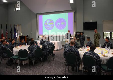 La base navale américaine de Naples, Italie (oct. 2, 2017). Michelle J. Howard, commander, U.S. Naval Forces Europe-afrique et commandant, Commandement Allié des Forces de Naples, est présenté un cadeau par commande de la flotte des États-Unis 6e Master Chief Richard O'Rawe 2 oct., 2017. Les Forces navales des États-Unis, dont le siège social est situé à Europe-afrique, Naples, Italie, supervise les opérations navales et mixte, souvent de concert avec ses alliés, le joint, et inter-organismes partenaires, pour permettre des relations durables et d'augmenter la vigilance et la résistance à l'Europe et l'Afrique. Banque D'Images