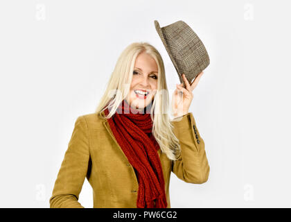 Jolie femme en vêtements d'hiver mettre sur Chapeau Trilby against white background Banque D'Images