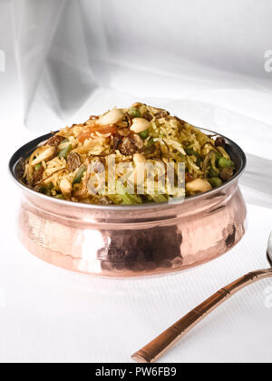 BIRYANI DE LÉGUMES SERVI DANS UN HANDI EN CUIVRE. Il EST FAIT AVEC DU RIZ ET LÉGUMES MIXTES LACÉE AVEC MASSALA ET GARNIE DE NOIX ET RAISINS SECS Banque D'Images