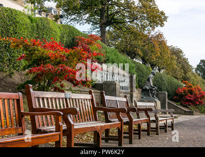 Bancs en bois dans les jardins de Princes Street avec feuille d'érable rouge couleurs à Scottish American War Memorial, Édimbourg, Écosse, Royaume-Uni Banque D'Images