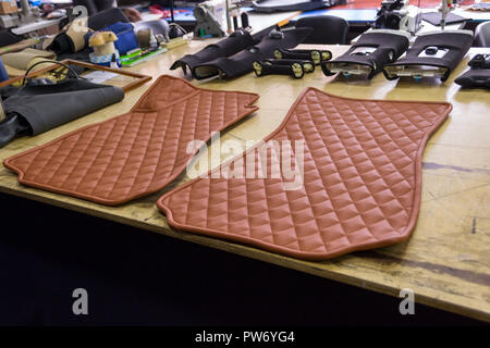 Location de tapis faits main en 3D avec des coutures en forme de diamant de couleur marron à partir de fils en cuir véritable pour les passagers avant d'un véhicule à l'architecture d'intérieur Banque D'Images