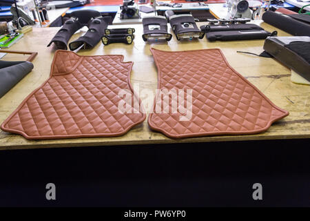 Location de tapis faits main en 3D avec des coutures en forme de diamant de couleur marron à partir de fils en cuir véritable pour les passagers avant d'un véhicule à l'architecture d'intérieur Banque D'Images