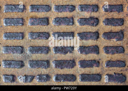 Une vue rapprochée de l'ancien égout rouillée éclosent sur une vieille plaque de métal. Vue de dessus. Banque D'Images