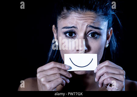 Close up portrait dramatique de femme triste de se cacher sa dépression avec sourire peint sur papier dans l'émotion humaine souffrant en silence la dépression iso concept Banque D'Images