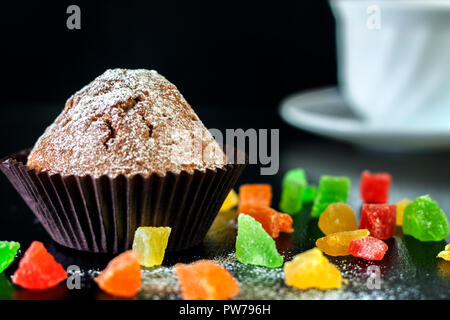Des muffins fraîchement cuits au four de fruits confits sur un tableau noir Banque D'Images