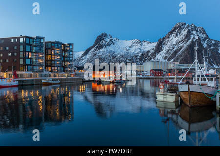 Les bateaux de pêche et les appartements à Svolvaer sur une claire nuit d'hiver avec une montagne et ciel bleu. Banque D'Images