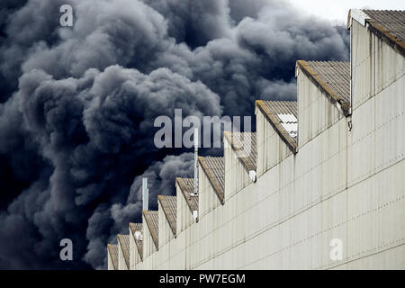 Panaches noirs de fumée provenant d'un rejet accidentel d'incendie industriels toxiques comme vu à partir d'un bâtiment de l'usine derrière un. Banque D'Images