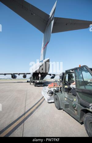 Aviateurs de la 123e Airlift Wing sur un équipement de charge West Virginia Air National Guard C-17 à la base de la Garde nationale aérienne du Kentucky à Louisville, Ky., 23 septembre 2017, à l'appui de l'Ouragan Maria les opérations de récupération. Trente-deux membres de la Garde nationale aérienne du Kentucky 123e du Groupe d'intervention d'urgence se déploient à San Juan, Puerto Rico, ainsi que l'équipement d'établir un centre de fret aérien à traiter des approvisionnements de secours. Banque D'Images