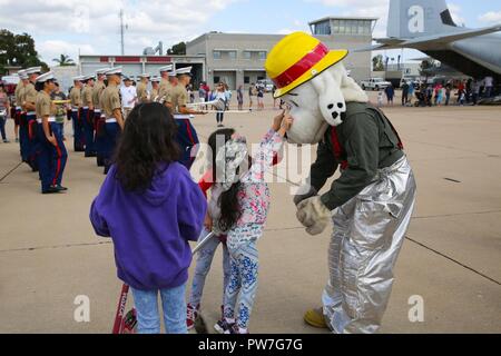 Les enfants qui fréquentent le 2017 Marine Corps Air Station Miramar Air Show au MCAS Miramar, Californie, jouer avec le chien Sparky, la mascotte de sauvetage d'aéronefs et de lutte contre l'incendie, comme l'aile d'avion Marine 3ème de parades à travers la foule, 23 septembre. Le thème pour le salon est "un hommage aux anciens combattants du Vietnam" et dispose de plusieurs représentations et affiche reconnaissant les sacrifices des anciens combattants du Vietnam. Le salon présente également des participants civils de classe mondiale, les équipes de démonstration de vol militaire, les capacités du groupe de travail air-sol marin et célèbrent notre relation de longue date avec ou Banque D'Images