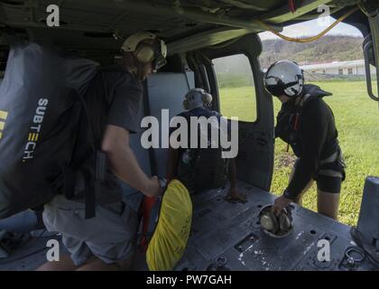 La DOMINIQUE (sept. 23, 2017) Aircrewman Naval (hélicoptère) 2e classe John Malico à partir d'hélicoptères de combat de la mer 22 (HSC-22), affecté à l'assaut amphibie USS Wasp LHD (1), aide les citoyens américains charger dans un Sea Hawk MH-60S au cours des efforts de secours à la suite de l'Ouragan Maria. Le ministère de la Défense soutient l'Agence des États-Unis pour le développement international (USAID), le principal organisme fédéral, en aidant les personnes touchées par l'Ouragan Maria afin de minimiser la souffrance et est une composante de l'ensemble de l'intervention. Banque D'Images