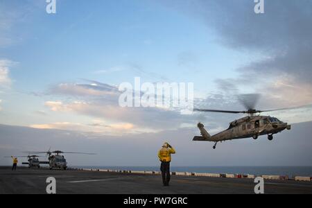 Mer de Chine orientale (sept. 25, 2017) MH-60S hélicoptères Sea Hawk, attribué à l'île de 'chevaliers' hélicoptère Escadron combat naval (HSC), le formulaire 25 débarquer d'assaut amphibie USS Bonhomme Richard (DG 6). Bonhomme Richard, navire amiral du Bonhomme Richard groupe amphibie, fonctionne en Indo-Asia-région du Pacifique pour améliorer les partenariats et être une force de réaction pour prêt à tout type d'imprévus. Banque D'Images