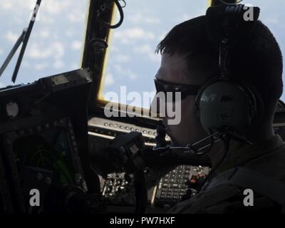 Le Capitaine Justin White, un projet pilote avec le 15e Escadron d'opérations spéciales, les analyses de l'horizon lors d'une mission d'aide humanitaire au-dessus des Caraïbes, le 24 septembre, 2017. Des équipages d'avec la 15ème task force conjointe déplacé SOS membres de Puerto Rico à la Martinique pour fournir une aide humanitaire à la population locale. Banque D'Images