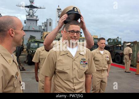 Océan Atlantique (septembre 1994). 16, 2017) responsable de la sécurité-incendie Controlman Kevin McFarland, centre, reçoit sa combinaison couvrir pendant un premier maître de cérémonie l'épinglage dans le poste de pilotage à bord de la classe de Harpers Ferry landing ship dock amphibie USS Carter Hall (LSD 50) 16 septembre, 2017. Carter Hall est déployé avec le groupe amphibie Bataan pour appuyer les opérations de sécurité maritime et les efforts de coopération en matière de sécurité dans le théâtre en Europe et au Moyen-Orient. Banque D'Images