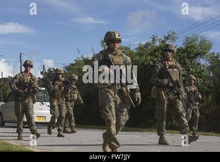 Les Marines américains avec 1er Bataillon, 8ème Marines, 3e Division de marines, III Marine Expeditionary Force patrol après son arrivée sur le Camp Gonsalves à Okinawa, Japon, Septembre 21, 2017 pour participer à une simulation de mission du personnel de recouvrement tactique. Un piège mission consiste à récupérer un blessé qui a éjecté d'un avion. Banque D'Images