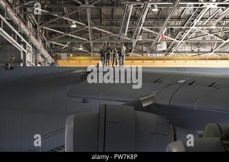 U.s. Air Force Airmen sondage le côté supérieur d'un C-5M Super Galaxy garée dans un hangar pour l'entretien, 22 septembre 2017, Travis Air Force Base, en Californie de la maintenance du 660 e Escadron de maintenance des aéronefs sont responsables de la sécurité et la fiabilité de la flotte, renforçant ainsi la puissance aérienne américaine à travers le monde. Banque D'Images