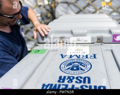 Mike Gomez, gestionnaire des communications, les stades de matériel de recherche et sauvetage pour l'Agence fédérale de gestion des urgences à la base de la Garde nationale aérienne Muniz, Carolina, Puerto Rico, le 26 septembre 2017 pour fournir aux opérations de sauvetage pour Porto Rico après l'Ouragan Maria a frappé l'île, septembre 2017. Le 156e Escadron de Port de l'antenne apporte son soutien à la FEMA ainsi que l'état et les autorités locales dans les efforts de sauvetage et de secours. Banque D'Images