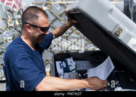 Mike Gomez, gestionnaire des communications, les stades de matériel de recherche et sauvetage pour l'Agence fédérale de gestion des urgences à la base de la Garde nationale aérienne Muniz, Carolina, Puerto Rico, le 26 septembre 2017 pour fournir aux opérations de sauvetage pour Porto Rico après l'Ouragan Maria a frappé l'île, septembre 2017. Le 156e Escadron de Port de l'antenne apporte son soutien à la FEMA ainsi que l'état et les autorités locales dans les efforts de sauvetage et de secours. Banque D'Images