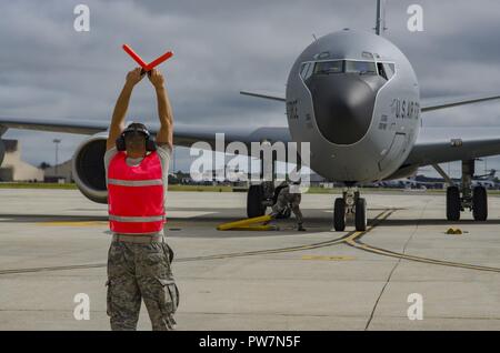 New Jersey Garde nationale aérienne aviateurs Senior Joshua O'Reilly, chef d'équipe, marshals un KC-135 Stratotanker aile 108e à sa place de stationnement sur l'aire de trafic à Joint Base McGuire-Dix-Lakehurst, N.J., le 26 septembre 2017. Le pétrolier et son équipage est de soutenir la base aérienne d'Andersen's mission de ravitaillement en cours. Banque D'Images