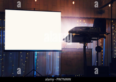 Ecran de projection immersive en blanc sur le mur. Lumière de projection dans l'obscurité. L'écran de projection des maquettes. Claire présentation moniteur sur mur. Diaporama fro Banque D'Images