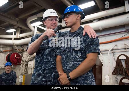 SASEBO, Japon (26 septembre 2017) Maître de Manœuvre Matelot Paul Price, d'El Paso, Texas, affecté à la station de transport amphibie USS Green Bay (LPD 20), parle avec Vice Adm. Tom Rowden, commandant de la marine, des forces de surface, au cours durant une session de questions et réponses d'un appel mains libres. Rowden visite Activités flotte Sasebo, accueil de 7e flotte américaine déployée sur l'avenir, les navires amphibies, pour mieux comprendre les défis et de préparation déployées pour discuter du rôle du nouveau Groupe de surface du Pacifique occidental de l'organisation. Banque D'Images