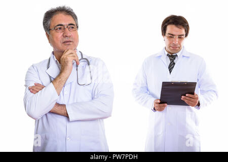 Studio shot of senior homme médecin Perse avec les jeunes par la pensée Banque D'Images
