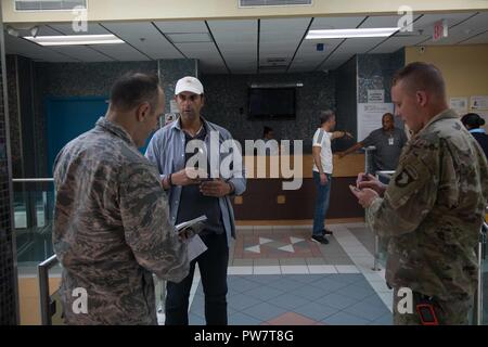 Fernando Davilla, directeur des opérations de l'hôpital médical des Caraïbes, parle avec l'U.S. Air Force Colonel James Bermudez, Directeur médical (à gauche), et de l'armée américaine Cpt. Benjamin Stork, médecin de l'aviation de combat de la 101e Brigade (CAB) (à droite), à Fajardo, Porto Rico, le 28 septembre 2017. Le personnel militaire américain recueillir et évaluer les capacités des installations médicales civiles locales. La 101e CAB va mener des efforts de secours et d'évacuation médicale à l'appui de la FEMA dans le processus de récupération de Puerto Rico après la dévastation créée par l'Ouragan Maria. Banque D'Images