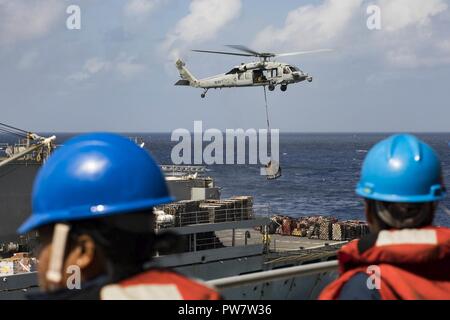 Mer des Caraïbes (sept. 28, 2017) Les marins à bord du navire d'assaut amphibie USS Kearsarge (DG 3) observer qu'un MH-60 Sea Hawk, transferts en hélicoptère à partir de l'approvisionnement en palettes de navire de soutien de combat rapide USNS Supply (T-AOE 6) au cours de ravitaillement en mer pour les activités poursuivies à Porto Rico. Kearsarge participe à des efforts de secours à la suite du cyclone Maria. Le ministère de la Défense soutient l'Agence fédérale de gestion des urgences, le principal organisme fédéral, en aidant les personnes touchées par l'Ouragan Maria afin de minimiser la souffrance et est une composante de l'ensemble de l'ensemble du gouvernement Banque D'Images