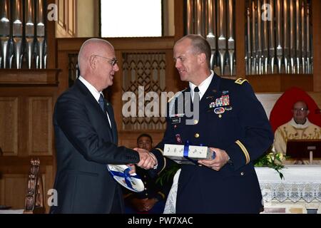 De gauche à droite, le Dr Giuseppe Petronzi Vicenza, chef de police et le lieutenant-colonel de l'armée américaine Edward Twaddel, commandant adjoint de la 173e Brigade aéroportée, l'échange de cadeaux au cours de la fête de Saint Michel, à l'église de Santa Maria dei Servi à Vicenza, en Italie, le 29 septembre, 2017. Saint Michel est le patron pour les parachutistes et les forces d'application de la loi italienne. Banque D'Images