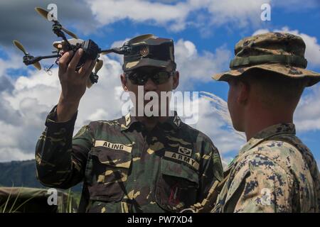 Le Major de l'Armée Philippine John B. Aling avec centre de formation interarmées et interalliées, Corps des Marines des États-Unis et le Cpl. Lucas A. Dussaut, un assaultman avec l'Équipe de débarquement du bataillon, 3e Bataillon, 5ème Marines, 31e Marine Expeditionary Unit, démontrer les capacités d'un système de surveillance des véhicules aériens au Colonel Ernesto P. Ravina Air Base, Philippines, le 2 octobre 2017. BLT 3/5 est l'exploration des concepts et des nouvelles technologies comme la force de la mer dédié à Dragon 2025, une initiative du Marine Corps pour préparer les futures batailles. Éléments du BLT 3/5 sont actuellement déployés à l'appui de la 3e Marin Banque D'Images