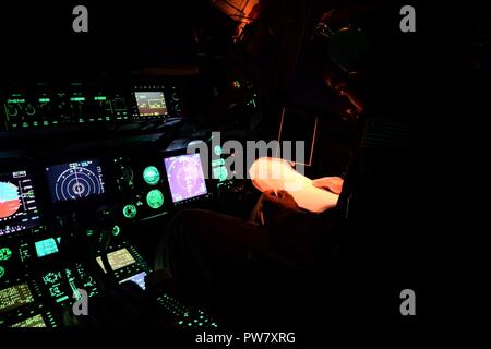 Premier Lieutenant Justin Collins, Escadron de transport aérien 3d atteindre 7170 pilote, passe par des procédures en vol dans un C-17 Globemaster III, en route vers San Juan, Puerto Rico, 30 septembre 2017. Atteindre 7170 livré 118 000 livres de repas prêt à manger et de l'eau en bouteille pour être distribués à travers un Porto Rico dévasté avec l'aide d'aviateurs de la 123e groupe d'intervention d'urgence. Banque D'Images