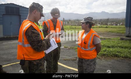 Les Marines américains avec la 26e Marine Expeditionary Unit (MEU) avec les marins de la marine américaine avec 2 Bataillon de construction amphibie, discuter d'un des centres de distribution locaux dans les procédures d'aide aux municipalités autour de Porto Rico avec Porto Rico Air National Guard Senior Airman Karen Ocasio, à l'appui de l'Ouragan Maria les efforts de secours à Canovanas, Porto Rico, 1 octobre, 2017. Le ministère de la Défense soutient l'Agence fédérale de gestion des urgences, le principal organisme fédéral, en aidant les personnes touchées par l'Ouragan Maria afin de minimiser la souffrance et est l'une composante de l'ensemble des g Banque D'Images