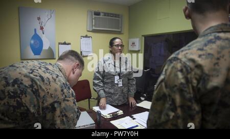 Les Marines américains avec la 26e Marine Expeditionary Unit (MEU) et de la Marine Les marins à la construction 2 bataillon amphibie, discuter d'un des centres de distribution locaux dans les procédures d'aide aux municipalités autour de Porto Rico avec Porto Rico Air National Guard Senior Airman Zulma Diaz Ortiz à l'appui de l'Ouragan Maria les efforts de secours à Canovanas, Porto Rico, 1 octobre, 2017. Le ministère de la Défense soutient l'Agence fédérale de gestion des urgences, le principal organisme fédéral, en aidant les personnes touchées par l'Ouragan Maria afin de minimiser la souffrance et est une composante de l'ensemble de l'ensemble du gouvernem Banque D'Images