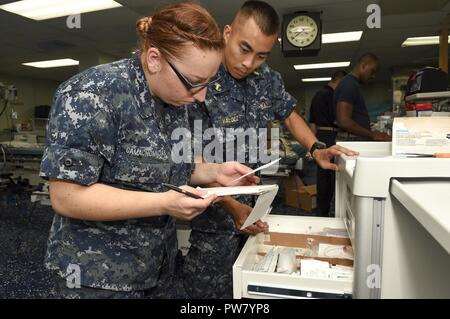 Océan Atlantique (oct. 2, 2017) - Camachomacias Hospitalman Kelly (à gauche), de la Naval Medical Center Portsmouth, et Ensign Justin Valdez, une infirmière d'orthopédie à partir de la NMCP, infirmière de chevet stocks à bord du chariot de transport maritime militaire du Commandement de navire-hôpital USNS Comfort (T-AH 20) alors qu'il se prépare pour les opérations humanitaires à Porto Rico. Le ministère de la Défense soutient l'Agence fédérale de gestion des urgences, le chef de l'agence fédérale pour aider les personnes touchées par l'Ouragan Maria afin de minimiser la souffrance et est une composante de l'ensemble de l'intervention. Banque D'Images