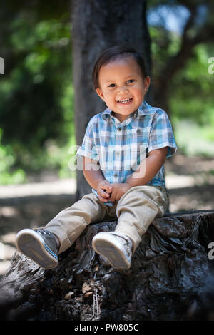 Joli garçon mexicain avec chemise à carreaux et grand sourire en santé avec les dents de bébé assis en plein air durant l'été dans le parc national de Californie Banque D'Images