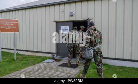 La CPS de l'armée américaine. Shaqueel Tabb et le Cpl. Zachery Frederick, à la fois avec 39e Bataillon des transmissions stratégiques, entrez l'Engagement Formateur Compétences bâtiment 2 avec des protections, après un 12-mile ruck mars et passe à travers un nuage de gaz CS dans l'initiative de l'autre, sur la base aérienne de Chièvres, Belgique, 20 août 2017. Banque D'Images