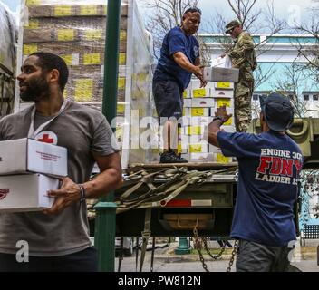 Le Sgt. Crew Gill, un agent de la police militaire affecté à la 3ème commande soutien expéditionnaire, les pompiers du service des incendies de la ville de New York, et une croix rouge aide télécharger les repas prêts-à-manger, d'un scanner à plat militaire le 2 octobre 2017, à Vieques. La priorité absolue du Ministère de la défense, de travailler ensemble à l'appui de l'Agence fédérale de gestion des urgences, et les autorités locales à Porto Rico est de fournir les moyens de sauvetage et au maintien de la vie, à ceux qui sont dans les zones touchées. Banque D'Images