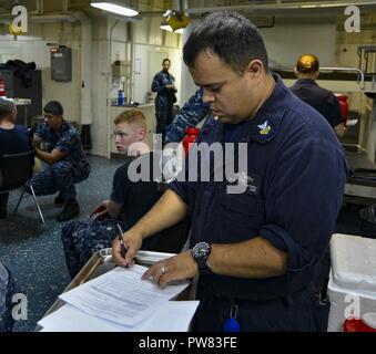 MAYPORT, Floride (oct. 02, 2017) 1ère classe Corpsman Hôpital Erick Villatoro vérifie un formulaire avant d'administrer un vaccin contre la grippe adultes dans le service de médecine à bord du navire d'assaut amphibie USS Iwo Jima (DG 7). Iwo Jima est retourné à son port d'attache après avoir récemment terminé premiers secours humanitaire après l'ouragan de l'Irma les côtes de Key West, Floride. Banque D'Images