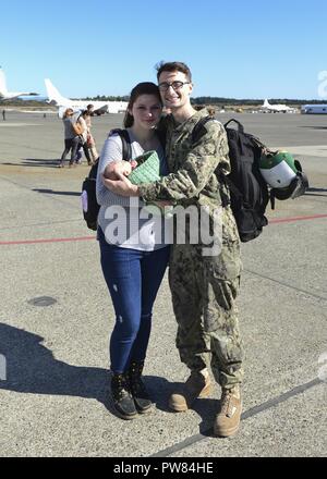 OAK Harbor, Washington (Octobre 03, 2017) l'Aviation 3e classe Mécanicien structurels Evan Vokes, affecté à l'Escadron de patrouille (VP) 46 l'île, pose pour une photo avec sa famille en arrivant chez d'un déploiement dans le Naval Air Station Whidbey Island. VP-46 a récemment terminé un déploiement de sept mois au 5e, 6e et 7e flotte domaines de responsabilité au cours de laquelle ils ont fourni un appui à l'Opération Détermination inhérente. Banque D'Images