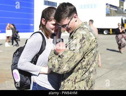 OAK Harbor, Washington (Octobre 03, 2017) l'Aviation 3e classe Mécanicien structurels Evan Vokes, affecté à l'Escadron de patrouille (VP) 46, se réunit avec son bébé pour la première fois à leur retour d'un déploiement dans le Naval Air Station Whidbey Island. VP-46 terminé un déploiement de sept mois au 5e, 6e et 7e flotte domaines de responsabilité au cours de laquelle ils ont fourni un appui à l'Opération Détermination inhérente. Banque D'Images