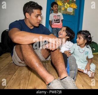 MANAMA, Bahreïn (30 sept. 28, 2017) 3ème classe Yeoman Samuel Gonzalez, de Ankeny, Iowa, affecté à la classe Ticonderoga croiseur lance-missiles USS Princeton (CG 59), interagit avec les étudiants de l'Institut régional d'apprentissage actif (RIA) École à Bahreïn lors d'un projet de service volontaire. RIA est un organisme sans but lucratif l'école Cours d'anglais britannique qui fournit des services éducatifs aux enfants. Princeton est déployée dans la zone 5e flotte américaine des opérations à l'appui d'opérations de sécurité maritime visant à rassurer les alliés et les partenaires, et de préserver la liberté de navigation et la libre circulation de l'co Banque D'Images