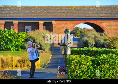 Les femmes prenant des photo de la statue de comédien britannique Les Dawson dans la paix et le bonheur dans le jardin St Annes on Sea, Lancashire, Royaume-Uni Banque D'Images