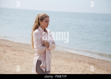 Blonde pensivement promenades sur la plage de sable de mer 1 Banque D'Images